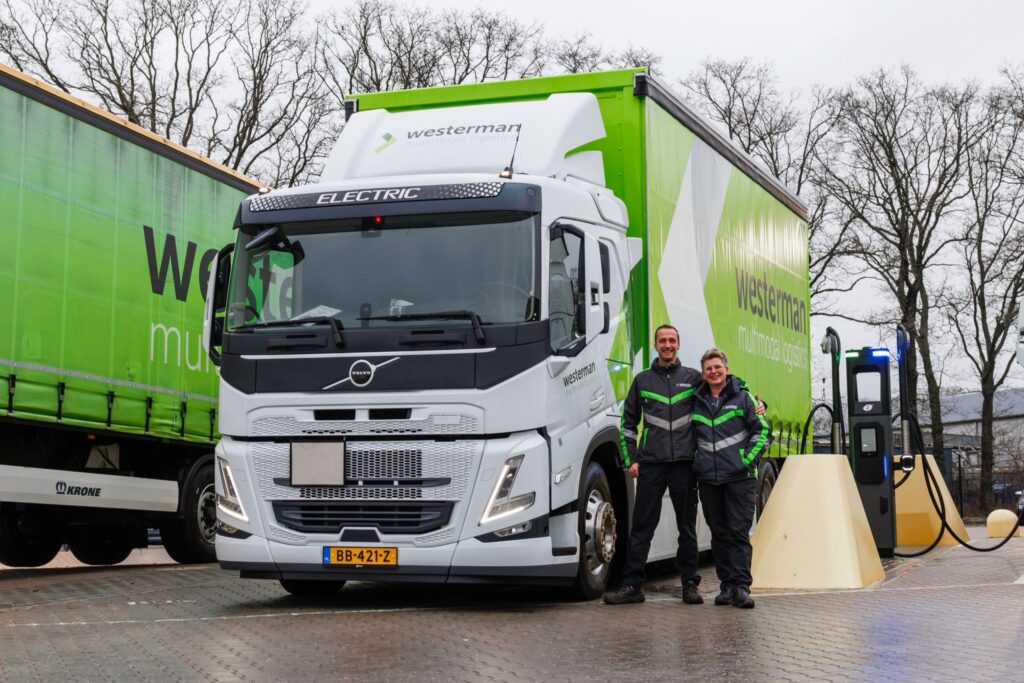 Twee medewerkers voor een nieuwe elektrische bakwagen op het laadplein.