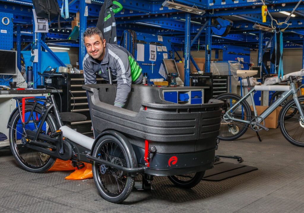 Werknemer is bezig met afmontage bakfiets